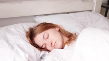 Genç sarışın kız yatakta uyuyor. Rüya kavramı