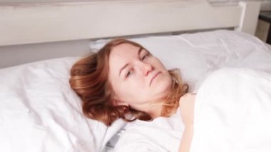 Genç sarışın kız yatakta uyuyor. Beyaz yatak. İyi sabahlar. Rüya kavramı