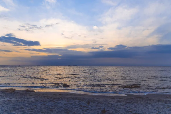 Beautiful blue red sunrise on the shore of the ocean or sea. Clear water and waves on the shore — 스톡 사진