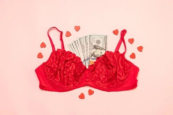 Roter Spitzen-BH mit Geldbündel auf rosa Hintergrund — Stockfoto