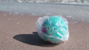 Globe ball toy in plastic bag on the beach