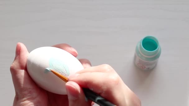 Frauenhand bemalt mit Pinsel ein weißes Ei — Stockvideo