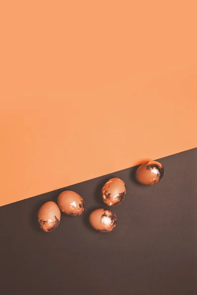 Composição feliz Páscoa de ovos de galinha de ouro espalhados em um fundo escuro. Foto vertical — Fotografia de Stock