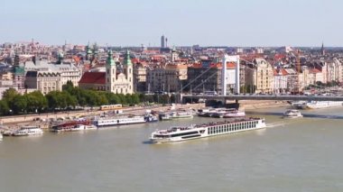 Budapest is the capital city of Hungary. A large boat with tourists floats on the Danube River on a sunny day. Erzebet Bridge.