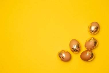 Sarı arka planda altın yumurtalar, telif alanı, üst manzara, düz. Mutlu bayramlar.