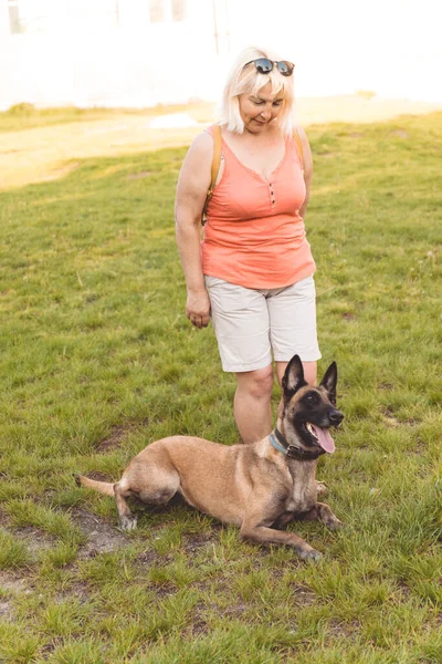 Erwachsene Frau mit belgischem Schäferhund im Park — Stockfoto