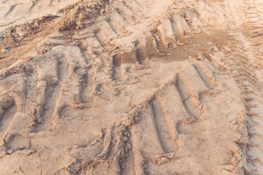 Kumda traktör tekerleği izleri var.