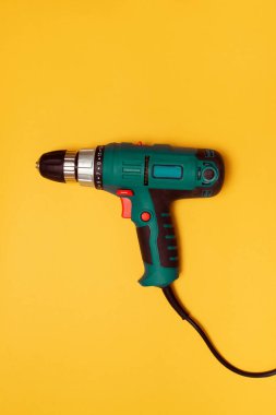 İnşaat işi için sarı zemin üzerinde elektrikli tornavida üst görünümü