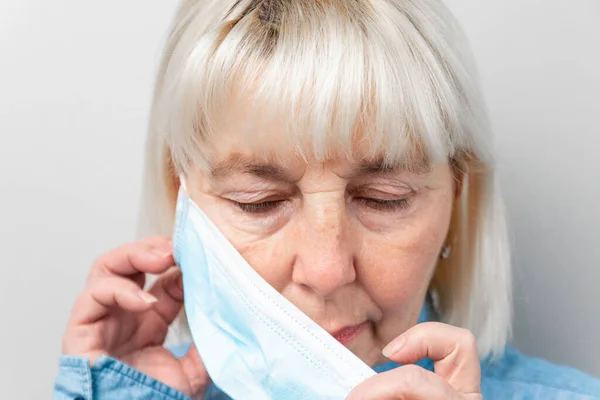 Kvinnan tar bort medicinsk mask — Stockfoto