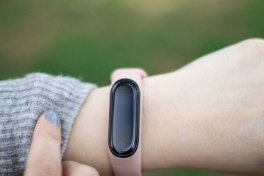 Genç, sportif bir kadının akıllı iz sürücünün yardımıyla spor gelişimini izlemesine yakın durun..