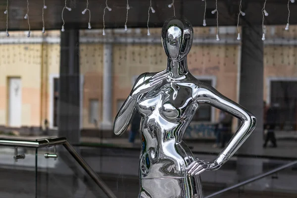 Stříbrná figurína stojící v okně obchodu — Stock fotografie