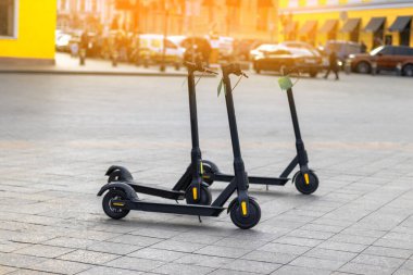 Elektrikli siyah scooterlar şehirde park halinde. Çevre dostu elektrik şehir taşımacılığı