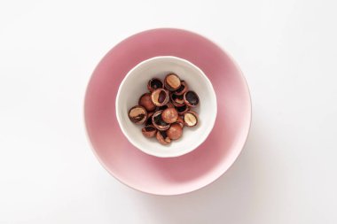 Gri arka planda pembe bir tabakta ceviz kabukları