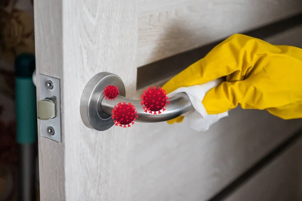 Una señora de la limpieza con guantes de látex de goma limpia el pomo de la puerta de metal con un desinfectante especial y una servilleta para proteger contra el virus y los gérmenes. Limpieza y limpieza en un hogar u hospital . — Foto de Stock