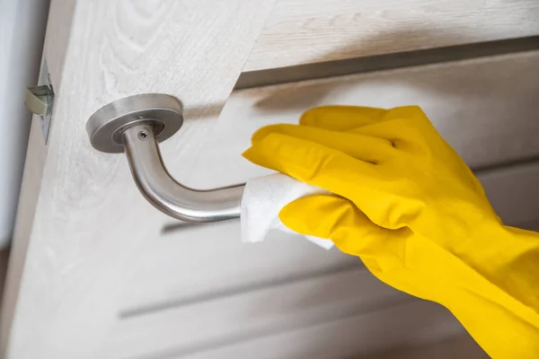 Coronavirus, covid 19 protection. Woman disinfects and cleans door handle with antibacterial wet wipes to protect against viruses, germs and bacteria during coronavirus — Stock Photo, Image