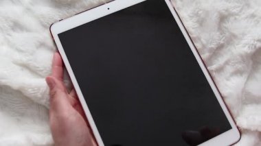 Bir insan alkol sıkar, spreyi elektronik tablete dezenfekte eder, mikrop, virüs ve bakteri ekranını temizler. Coronavirus, Covid 19