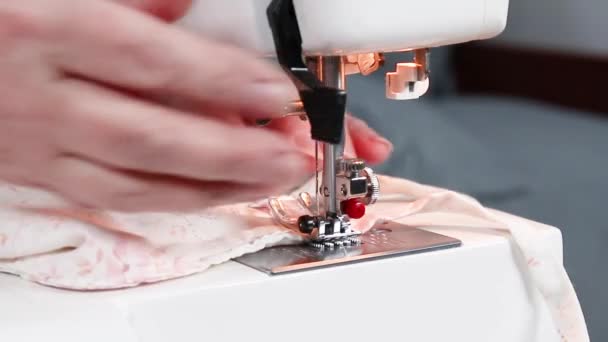Vista de perto do processo de costura. As mãos femininas cosem a máscara médica do tecido de algodão na máquina de costura durante uma pandemia de coronavírus . — Vídeo de Stock