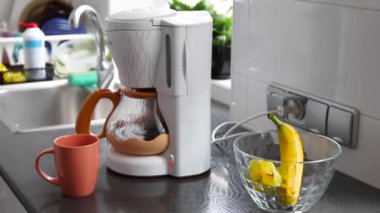 Evdeki şeffaf kahve makinesinde sıcak içecek espresso yapmak.