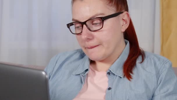 Oturma odasında dizüstü bilgisayarla çalışan yorgun genç bir kadının portresi.. — Stok video