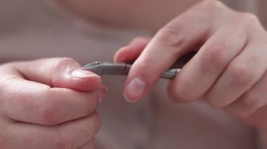 Kadın elleri tırnaklarını kesmek için metal tırnak makası kullanır. Vücut Bakımı Hijyeni
