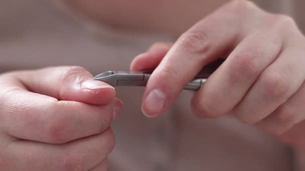 Kobiece dłonie używają metalowych obcinaczy paznokci do obcinania paznokci. Higiena ciała — Wideo stockowe