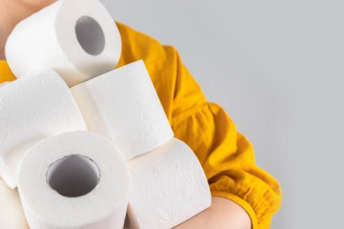 Taçlı virüs salgını çıkma korkusuyla birçok rulo tuvalet kağıdı taşıyan kadın elleri. Temel hijyen maddesi kıtlığı