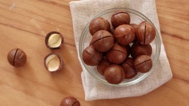 Cam kasede taze Macadamia fındıkları, ahşap bir yüzeyin üst manzarası. Düz yatıyordu. Yiyecek konsepti.