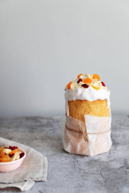 Fotokopi alanı olan gri bir arka planda kızılcık ve fındıklı Paskalya pastası, dikey fotoğraf