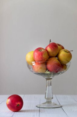 Sarı ve yeşil elmalı cam plaka. Gri bir arkaplanda, fotokopi alanı, dikey fotoğraf.
