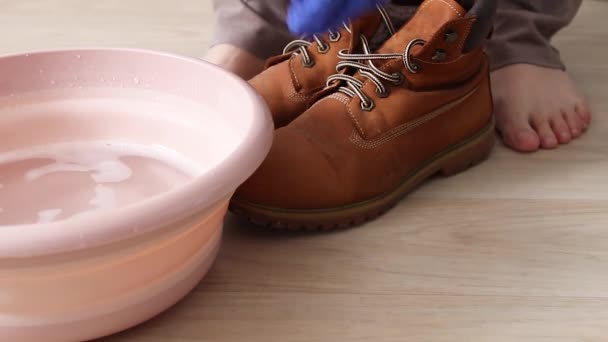 Donna che lava le scarpe con spugna sopra il bacino di plastica rosa — Video Stock