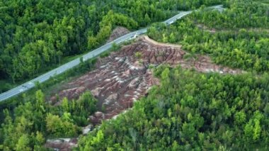 Hava: Cheltenham Badlands, Ontario Canada 'daki kuru toprak, orman, kahverengi ve beyaz toprak manzarası. Küçük nehirler üzerinde uçmak, kuru toprak, vahşi yer, Çorak Topraklar oluşumu, Queenston, ormanda yol 4K