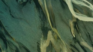 Delta nehrinin havadan görünüşü, İzlanda 'daki siyah kum. Siyah volkanik kum, buzul nehirleri, buzul erimiş su manzarası. Güzel kum, siyah kum, kara toprak. 4K