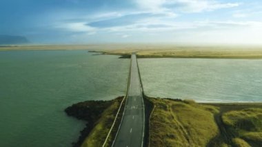 Yağmurlu bir günde ıssız bir köprünün havadan çekilmiş görüntüsü. Okyanus manzarası, uzun ve boş bir yol, vahşi bir yol, vahşi bir doğa. Güzel vahşi manzara. 4K
