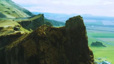 Kayalık uçurumun üzerinde uçan hava manzarası, dağ vadisini keşfetmek, sulu kar. Dağ zirvesinin havadan görünüşü, dağ manzarası. Dağ zirvesinin tepesinde. Doğa manzarası arka planı