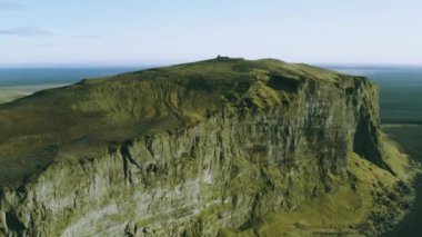 Çölün ortasındaki büyük bir dağın çarpıcı hava manzarası. Dağ bitki örtüsüyle kaplı. Dağın tepesinde..