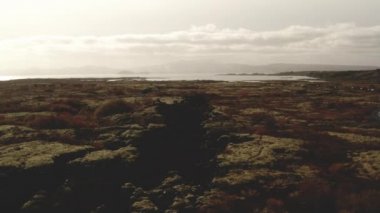 Drone View: İzlanda 'da çorak arazide uçuyor, göl uzaklarda.