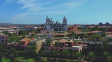 Plaj yakınlarındaki, palmiyeli olağanüstü tatil beldelerinin havadan görüntüsü. Döner hava manzaralı tropikal plaj tatil beldeleri, palmiyeler ve yüzme havuzları.