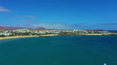 Playa Blanca 'nın engebeli kıyı şeridi tatil beldeleri, villalar, arka planda volkanik dağlar Lanzarote, Kanarya Adaları, İspanya .