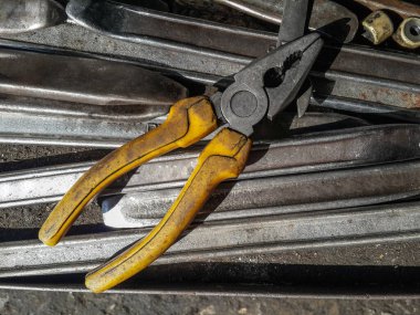 Yakın çekim Eski sarı pense, Yalıtımsız saplı çapraz pense Araç kutusunun içinde, Yatay