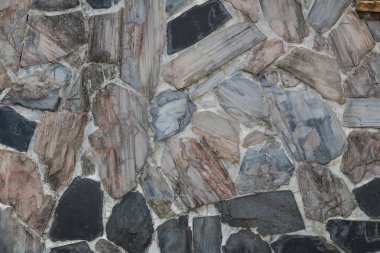 Taş duvar ve eski tuğla duvar, duvarlara yapıştırılmış çok renkli taşlar. Soyut