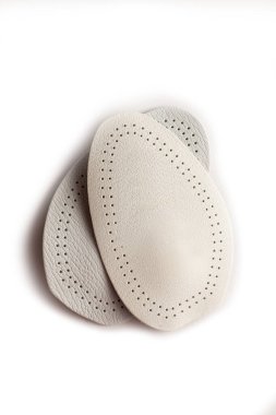 Beyaz arka planda izole edilmiş farklı bacak uzunluklarının düzeltilmesi için nasırlardan ortopedik silikon topuk.