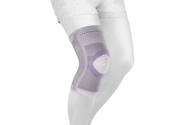 Diz Destek Kolu beyaz arka planda izole edilmiş bir bacak üzerinde. Ortopedik Anatomik Ortopedi. Diz sabitleme, yaralanma ve ağrı için diş telleri. Ortopedi. Ayak ortozu. Diz eklemi bandaj kolu. Elastik Spor 