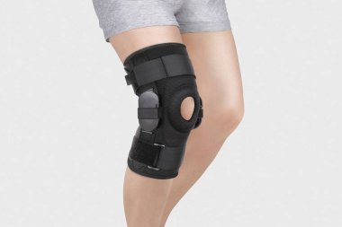 Diz Destek Kolu beyaz arka planda izole edilmiş bir bacak üzerinde. Ortopedik Anatomik Ortopedi. Diz sabitleme, yaralanma ve ağrı için diş telleri. Ortopedi. Ayak ortozu. Diz eklemi bandaj kolu. Elastik Spor 