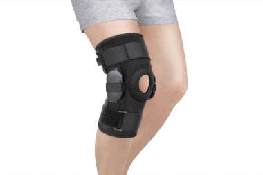 Diz Destek Kolu beyaz arka planda izole edilmiş bir bacak üzerinde. Ortopedik Anatomik Ortopedi. Diz sabitleme, yaralanma ve ağrı için diş telleri. Ortopedi. Ayak ortozu. Diz eklemi bandaj kolu. Elastik Spor 