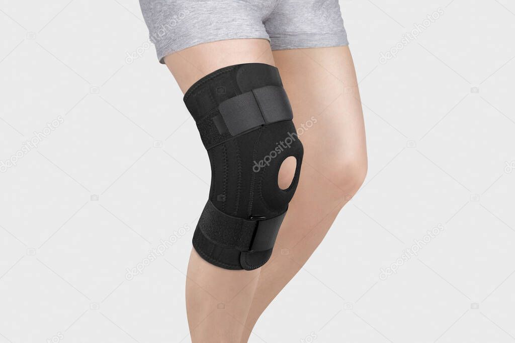 Knee Support Brace on leg isolated on white background. Orthopedic Anatomic Orthosis. Braces for knee fixation, injuries and pain. Orthotics. Foot orthosis. Knee Joint Bandage Sleeve. Elastic Sports