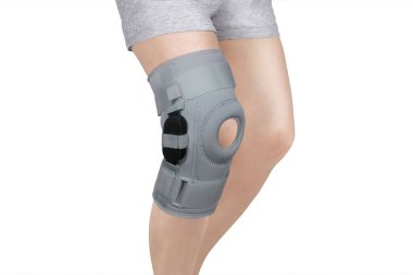 Diz Destek Kolu beyaz arka planda izole edilmiş bir bacak üzerinde. Ortopedik Anatomik Ortopedi. Diz sabitleme, yaralanma ve ağrı için diş telleri. Ortopedi. Ayak ortozu. Diz eklemi bandaj kolu. Elastik Spor