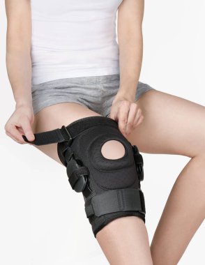 Diz Destek Kolu beyaz arka planda izole edilmiş bir bacak üzerinde. Ortopedik Anatomik Ortopedi. Diz sabitleme, yaralanma ve ağrı için diş telleri. Ortopedi. Ayak ortozu. Diz eklemi bandaj kolu. Elastik Spor