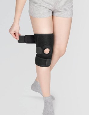Diz Destek Kolu beyaz arka planda izole edilmiş bir bacak üzerinde. Ortopedik Anatomik Ortopedi. Diz sabitleme, yaralanma ve ağrı için diş telleri. Ortopedi. Ayak ortozu. Diz eklemi bandaj kolu. Elastik Spor