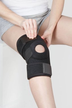 Diz Destek Kolu beyaz arka planda izole edilmiş bir bacak üzerinde. Ortopedik Anatomik Ortopedi. Diz sabitleme, yaralanma ve ağrı için diş telleri. Ortopedi. Ayak ortozu. Diz eklemi bandaj kolu. Elastik Spor