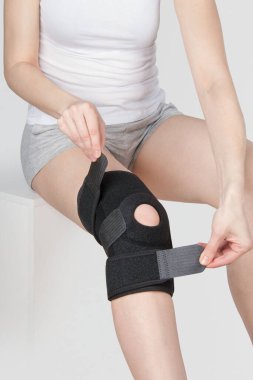 Diz Destek Kolu beyaz arka planda izole edilmiş bir bacak üzerinde. Ortopedik Anatomik Ortopedi. Diz sabitleme, yaralanma ve ağrı için diş telleri. Ortopedi. Ayak ortozu. Diz eklemi bandaj kolu. Elastik Spor